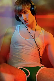Clothing Gallery: Young man in underwear with headphones in colorful light