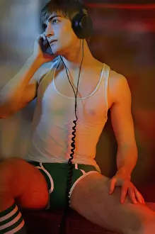 Thoughtful Prints: Young man in underwear with headphones in colorful light