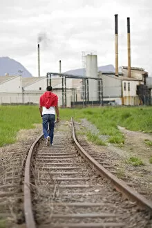 Young man walking on deserted railway