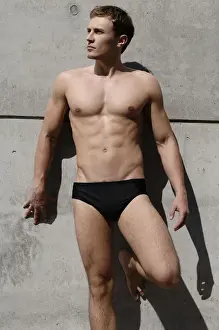 20 30 Prints: Young man wearing bathing trunks, leaning against a concrete wall