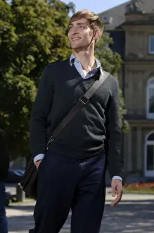 Jumper Prints: Young man wearing elegant clothing with a bag over his shoulder in front of the New Palace in Stuttgart