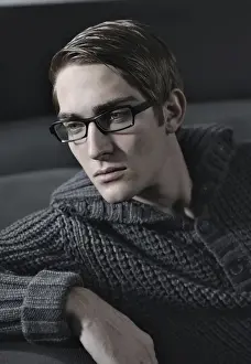 Jumper Prints: Young man wearing glasses sitting on a sofa