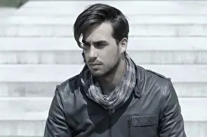 Contemplates Prints: Young man wearing a leather jacket in front of an open staircase, portrait