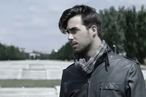 Young man wearing a leather jacket in front of an open staircase, portrait