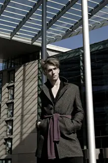 Contemplates Prints: Young man wearing an overcoat in front of modern architecture, fashion shoot