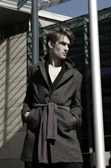 Shorthaired Prints: Young man wearing an overcoat in front of modern architecture, fashion shoot