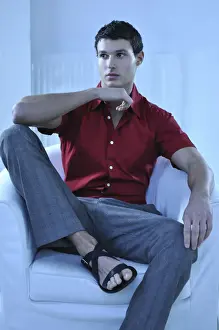 Sandals Prints: Young man wearing a red shirt sitting in an armchair