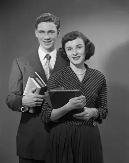 Knowledge Prints: Young man and woman holding books, portrait