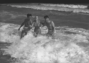 Ocean And Sea Prints: Two young man and woman playing in wave, (B&W)