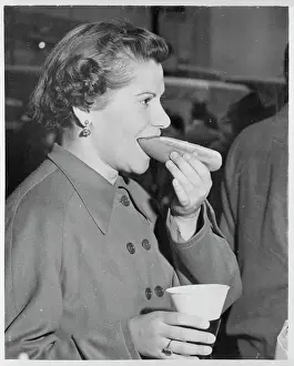 Young New York City Woman Eating a Hot Dog with Drink in Hand