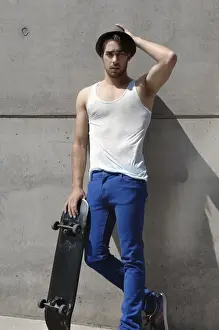 Athleticism Prints: Young skater in front of a concrete wall
