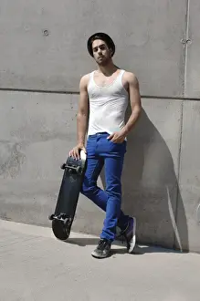 Leaning Prints: Young skater in front of a concrete wall