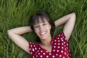 Images Dated 12th July 2011: Young woman, 25, lying in a meadow