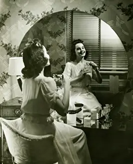Interior Space Prints: Young woman applying cream in front of mirror, (B&W)