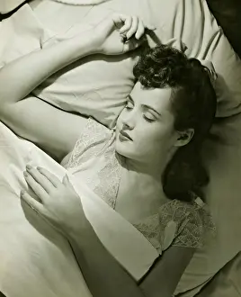 Closed Eyes Prints: Young woman asleep on bed, (B&W), close-up