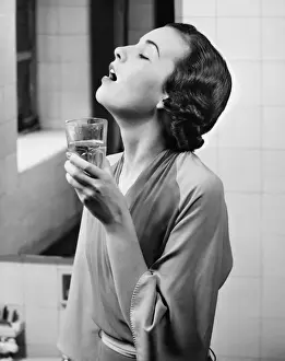 Dressing Gown Prints: Young woman in bathroom gargling water, (B&W)