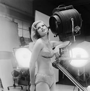 Iconic Bikini Collection: Young woman in bikini standing beside spotlight