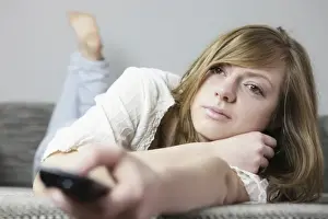 Hand Prints: Young woman on the couch with remote in her hand
