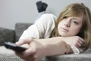 Hand Prints: Young woman on the couch with remote in her hand