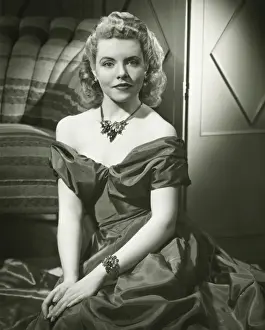 Bracelet Prints: Young woman in evening dress sitting indoors, (B&W), portrait