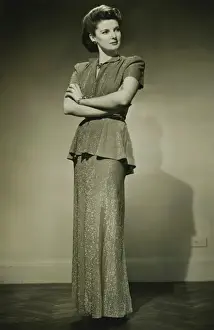 Arms Folded Prints: Young woman in fashionable dress standing in studio, (B&W)