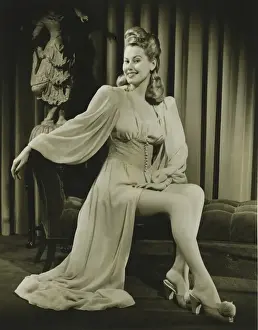 Young woman in fashionable nightdress sitting indoors, (B&W)