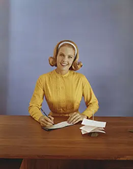 Headband Prints: Young woman filling out bank slip, smiling, portrait