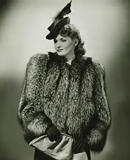 Stylish Prints: Young woman in fur coat and fashionable hat in studio, (B&W)