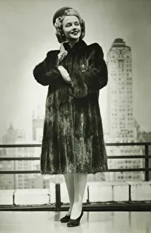 Railing Collection: Young woman in fur coat standing outdoors, (B&W)
