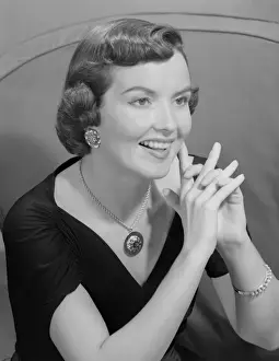 Young woman with hand clasped, indoors