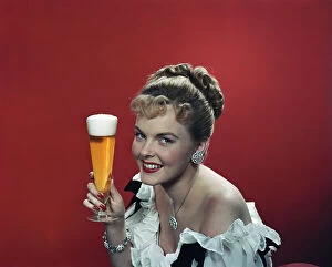Images Dated 18th July 2011: Young woman holding beer glass, smiling, portrait