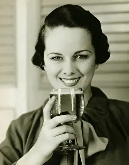 Beer Alcohol Prints: Young woman holding glass of beer, (B&W), portrait