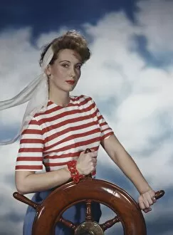 Young woman holding ship wheel, portrait