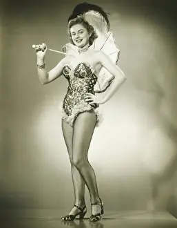 Corset Prints: Young woman holding umbrella standing in studio, (B&W)