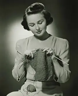 Focused Prints: Young woman knitting in studio, (B&W)