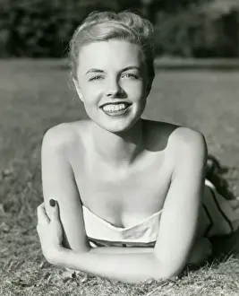 Hair Back Prints: Young woman lying on grass, smiling, portrait