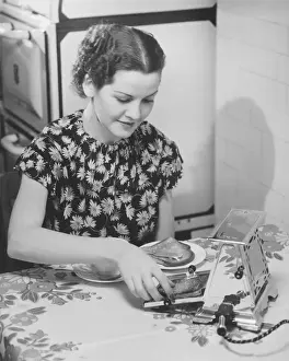 Preparing Food Prints: Young woman preparing toasts at kitchen table (B&W)