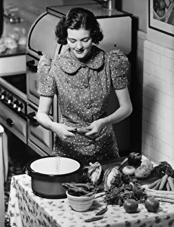 20 25 Years Gallery: Young woman preparing vegetables in kitchen, (B&W), elevated view