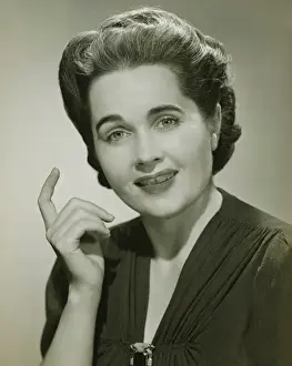 Finger Prints: Young woman with raised index finger in studio, (B&W), portrait