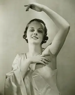 Nightgown Prints: Young woman raising hand, posing in studio, (B&W), portrait