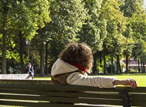 Young woman sitting on a bench watching a man speaking on the phone, Berlin, Germany, Europe