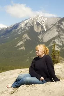 Images Dated 22nd October 2008: Young woman sitting in the mountains, Jasper, Canada