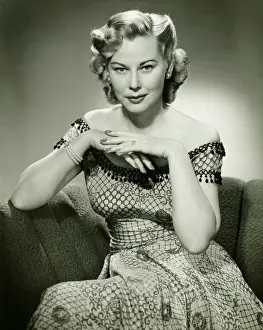 Permed Hair Prints: Young woman sitting on sofa, (B&W), portrait