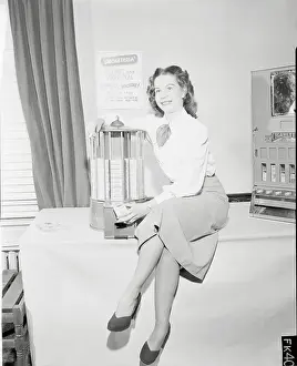 Young Woman Sitting on Table Beside Cigarette Machine