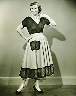 Hand On Hip Prints: Young woman smiling, posing in empty room, (B&W)
