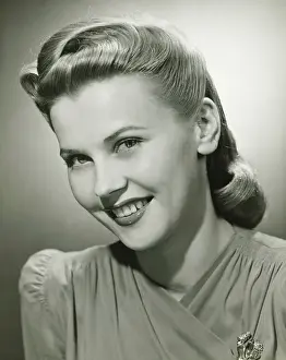 Permed Hair Prints: Young woman smiling in studio, (B&W), portrait
