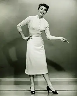 Permed Hair Prints: Young woman standing in empty room, gesturing, (B&W)