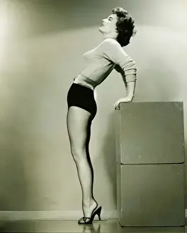 Leaning Prints: Young woman standing in studio, leaning backwards, (B&W)