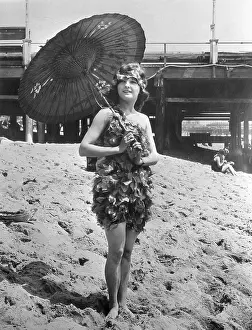 Stylish Prints: Young woman in stylish swimming costume posing on sandy beach