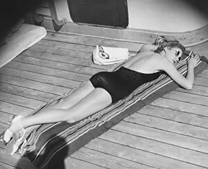 Boat Deck Gallery: Young woman sun tanning on cruiser deck (B&W), elevated view
